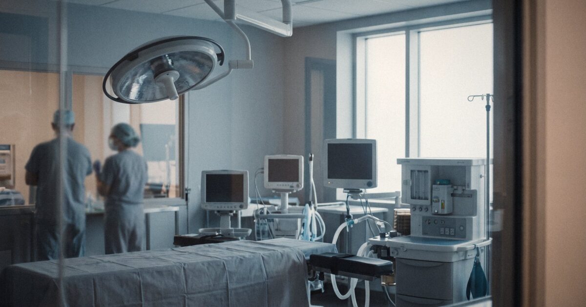 An empty operating room with surgical lights and equipment, cool tones